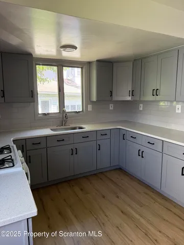 a kitchen with stainless steel appliances granite countertop a sink window and cabinets