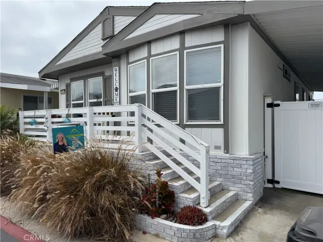 a view of a house with a small yard and wooden floor and fence