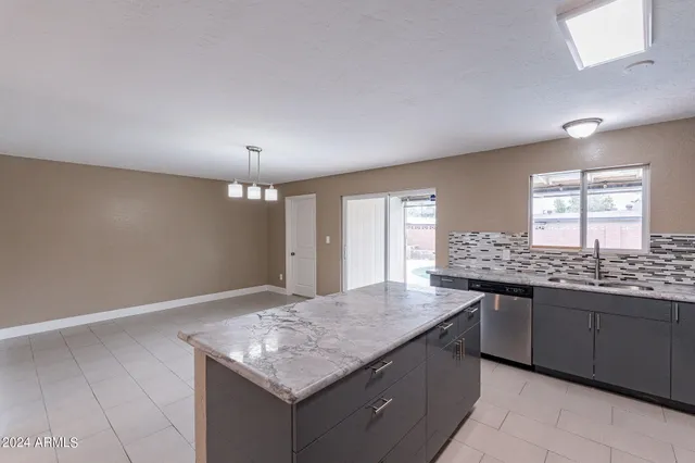 an empty room with kitchen island and wooden floor