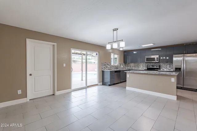a large kitchen with kitchen island a sink stainless steel appliances and cabinets