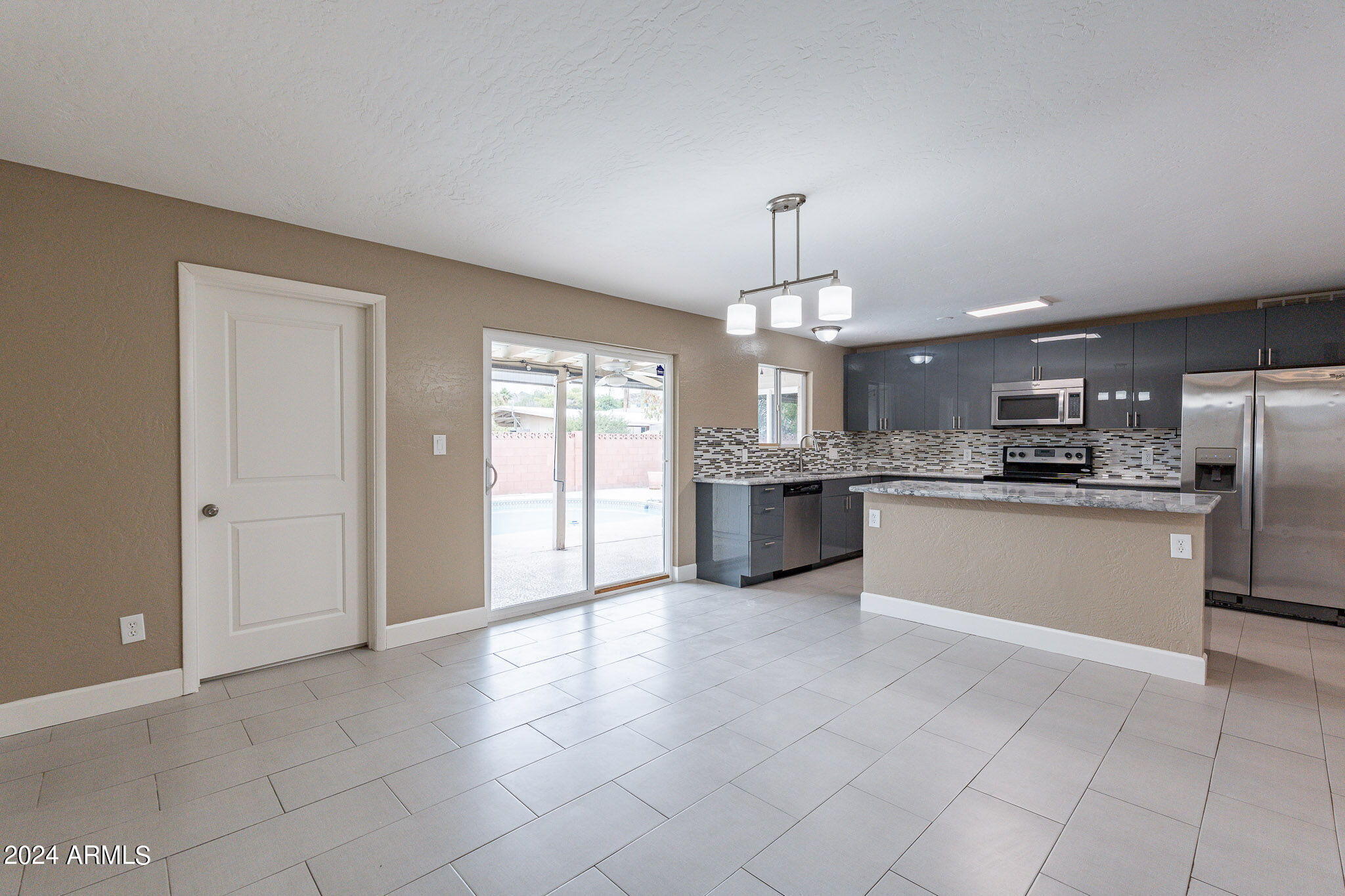 1320 East Orchid Lane Phoenix, AZ 85020 - Photo 22 of 48 a large kitchen with stainless steel appliances granite countertop a stove top oven a sink and a refrigerator
