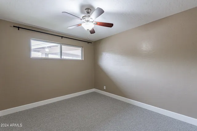 an empty room with a fan and a fan