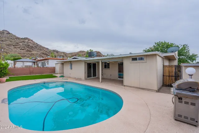 a backyard of a house with table and chairs