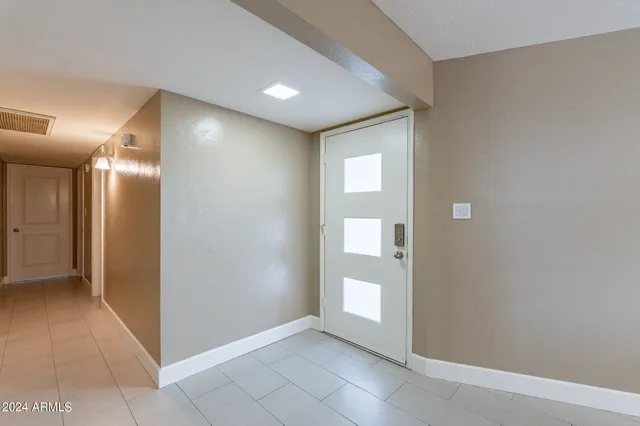 an empty room with windows and fireplace