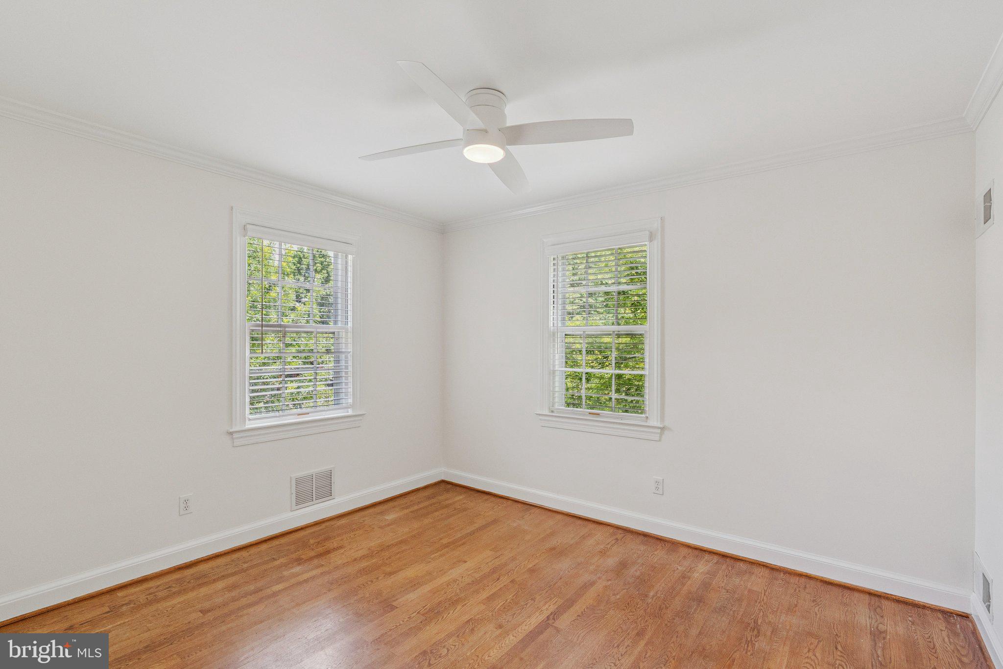 657 E Street Southeast Washington, DC 20003 - Photo 26 of 41 an empty room with wooden floor ceiling fan and windows