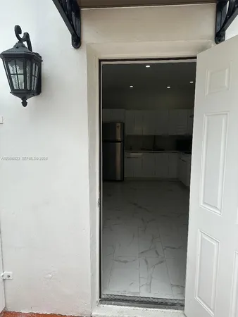 a kitchen with white cabinets and refrigerator