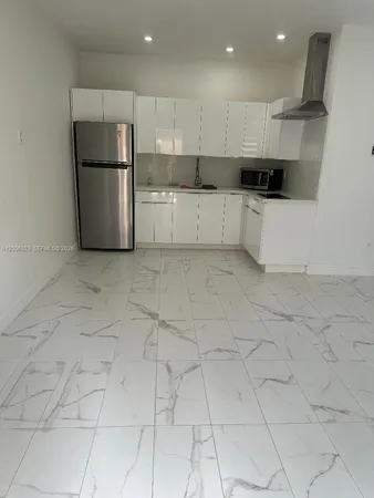 a kitchen with white cabinets and white appliances