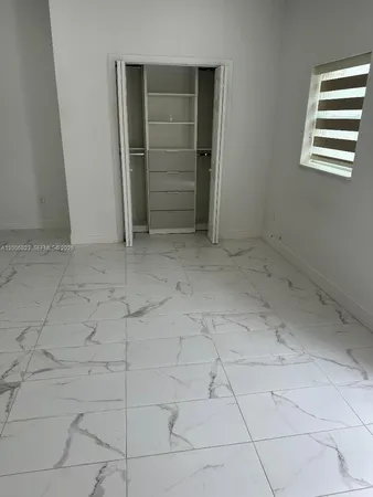 a white toilet sitting next to a shower