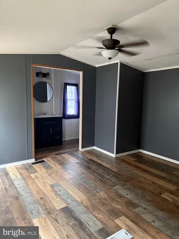 a view of empty room with wooden floor