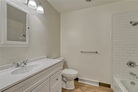 a bathroom with a granite countertop sink toilet a large mirror a bathtub and shower