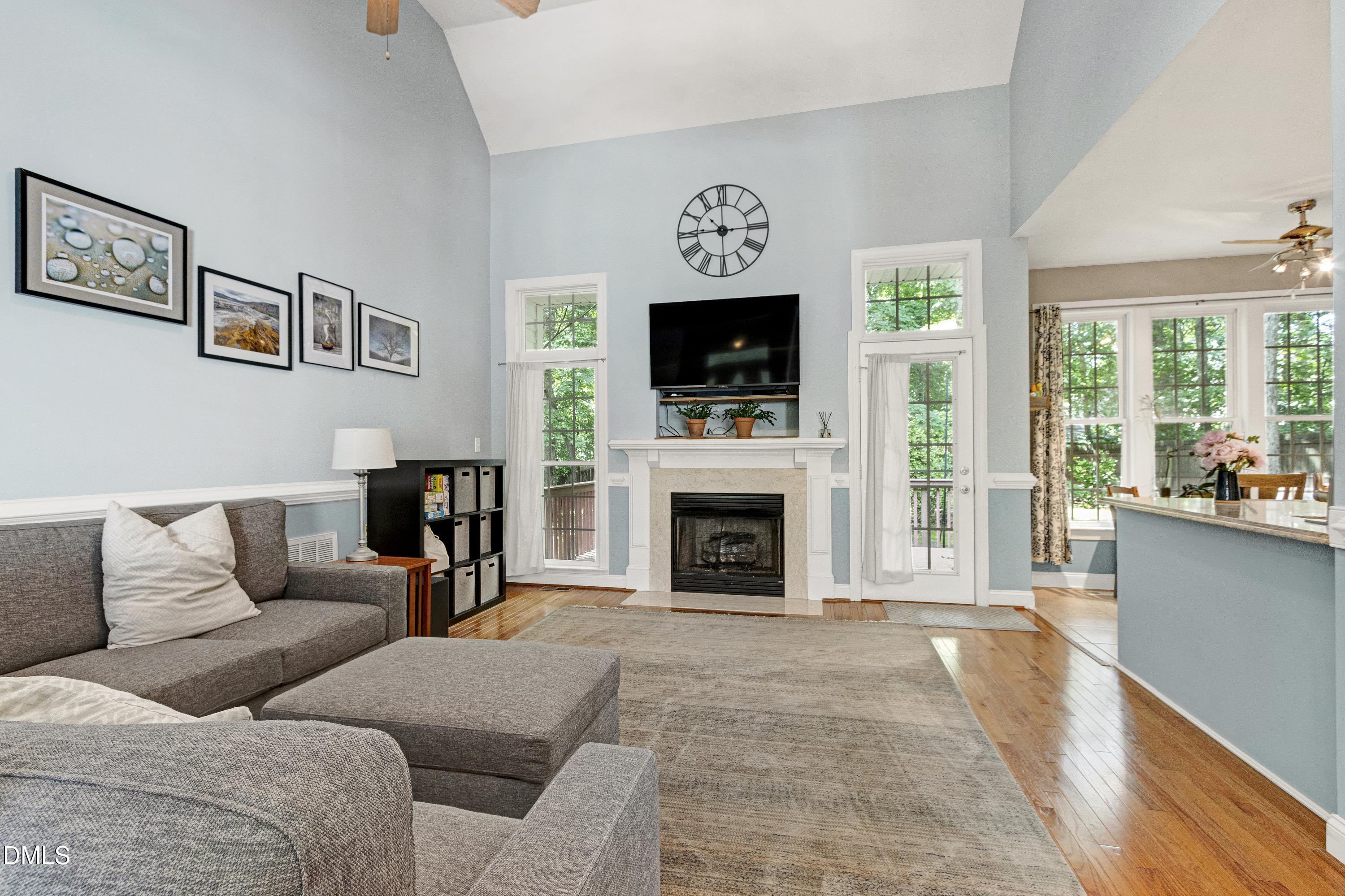 1320 Taylor Farm Road Raleigh, NC 27603 - Photo 12 of 56 a living room with furniture a flat screen tv and a fireplace