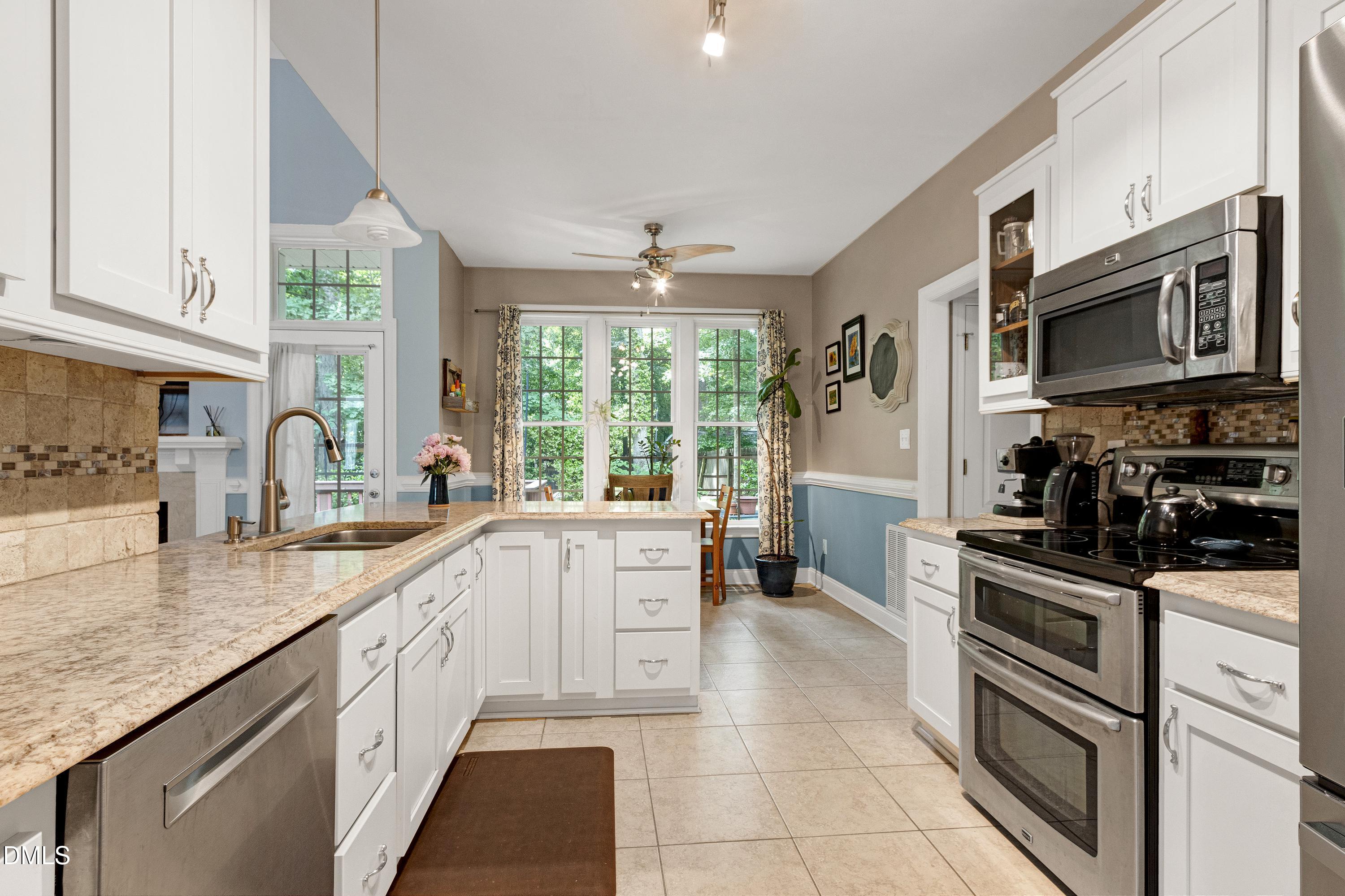 1320 Taylor Farm Road Raleigh, NC 27603 - Photo 21 of 56 a kitchen with granite countertop a sink stainless steel appliances and cabinets