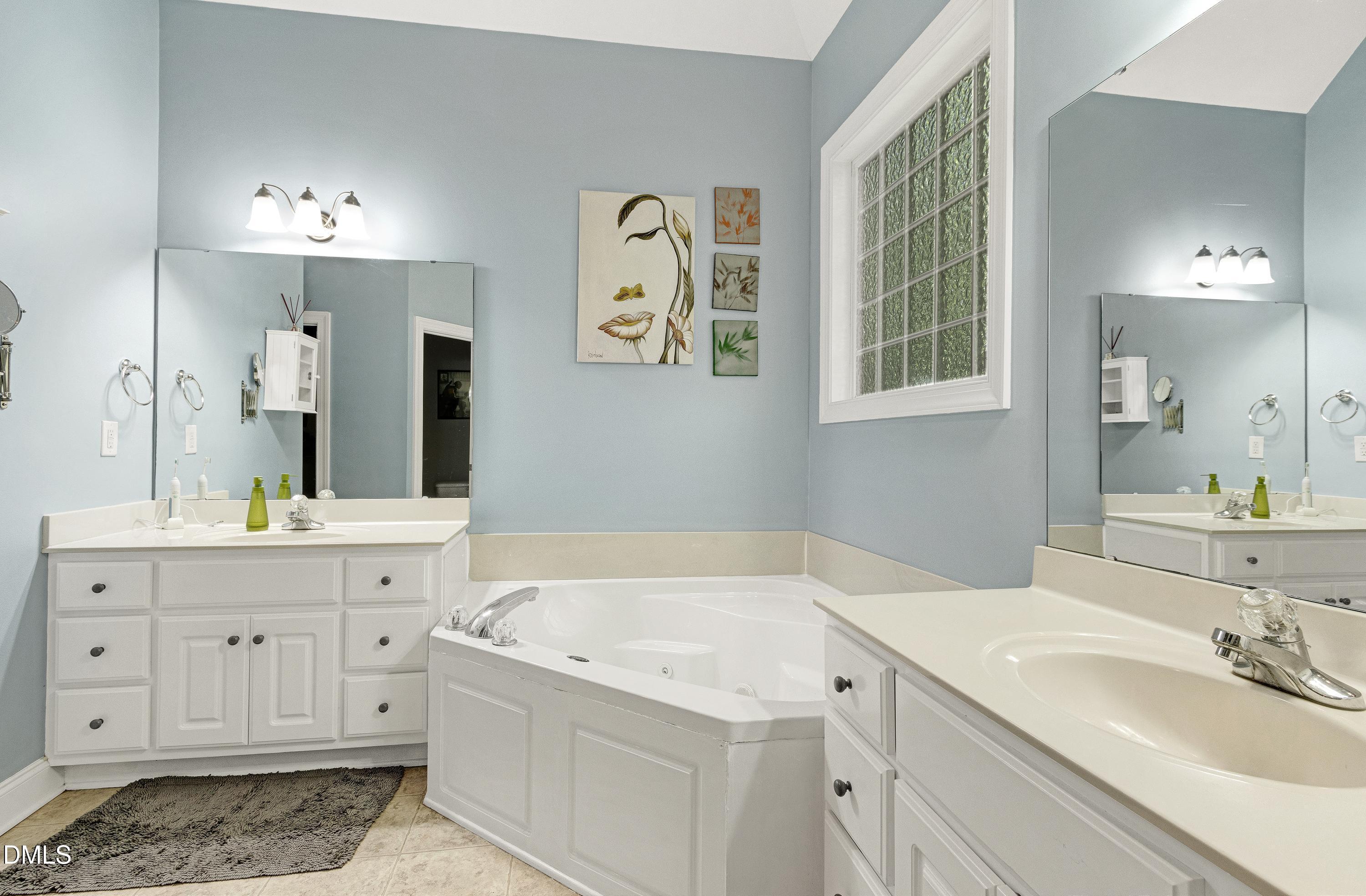 1320 Taylor Farm Road Raleigh, NC 27603 - Photo 25 of 56 a spacious bathroom with a granite countertop sink and a mirror