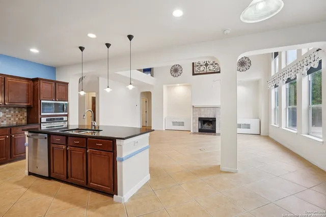 a kitchen with a sink a stove a refrigerator and a fireplace