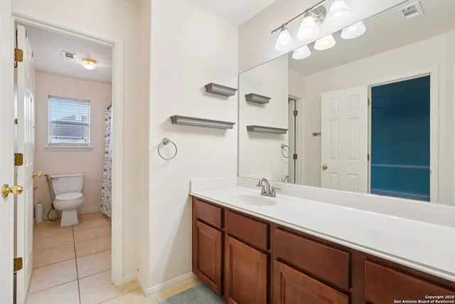 a bathroom with a toilet and shower curtain