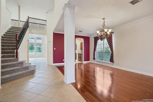 a view of a hallway with furniture and chandelier