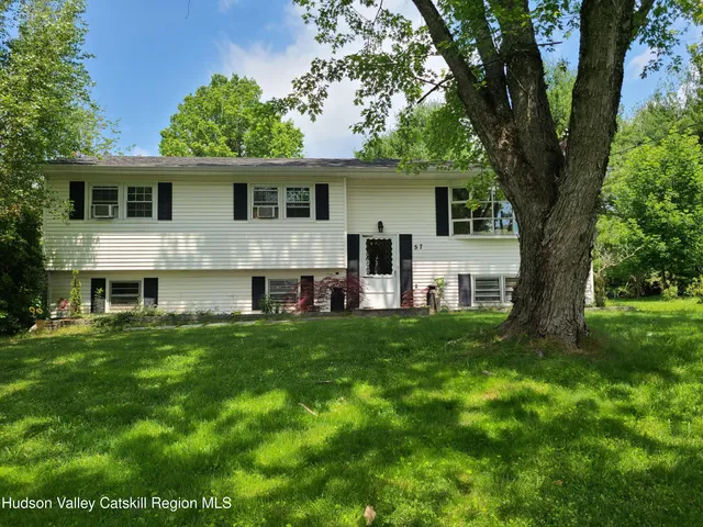a view of a yard in front of a house with large tree