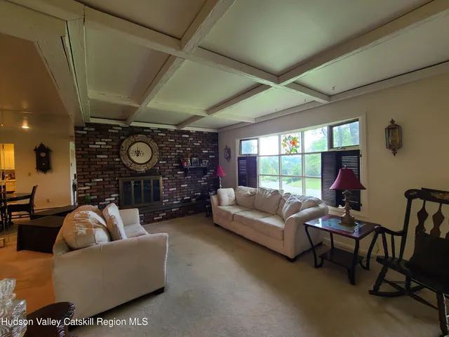 a living room with fireplace furniture and a large window