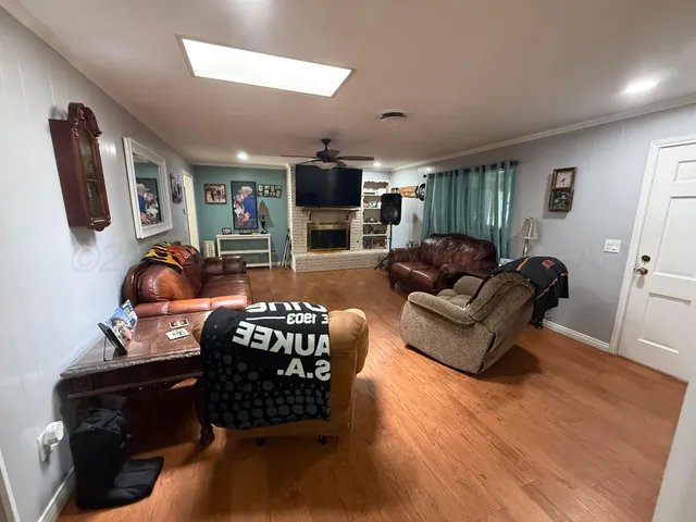 a living room with furniture a flat screen tv and kitchen view