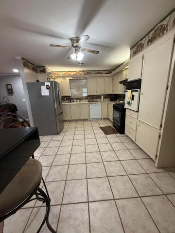 a kitchen with granite countertop a refrigerator and microwave