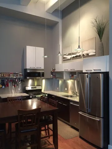 a kitchen with a refrigerator and a stove top oven
