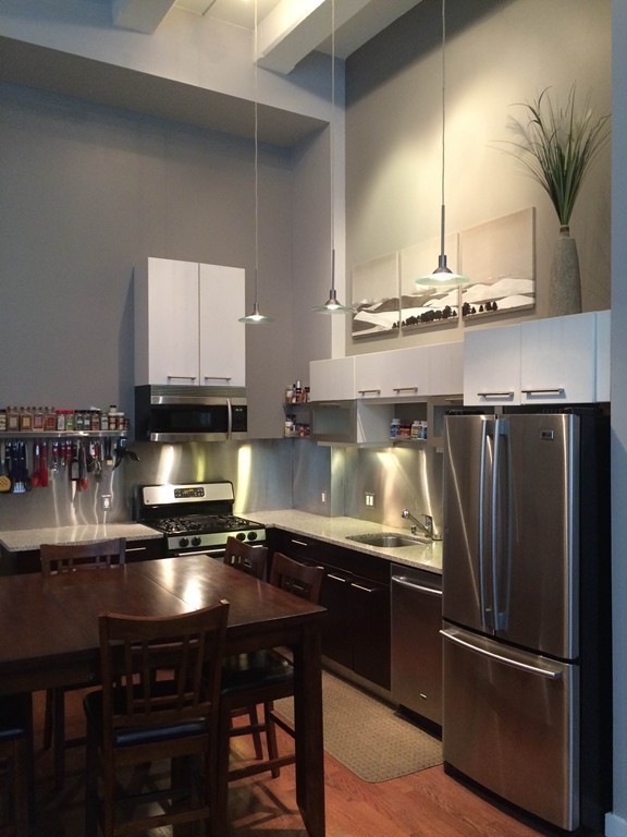 88 Kingston Street, Unit 1E Boston, MA 02111 - Photo 2 of 11 a kitchen with a refrigerator and a stove top oven