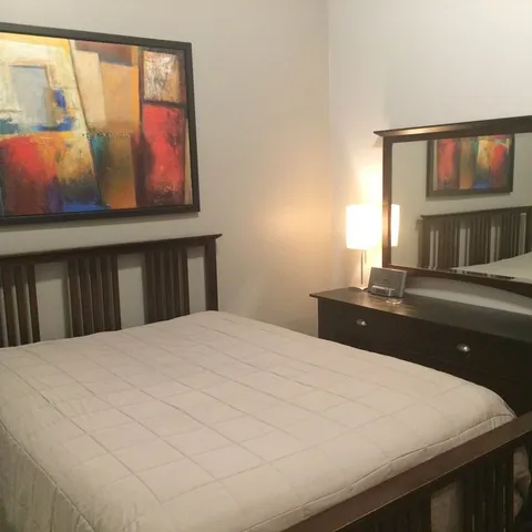 a bedroom with a bed and a night stand