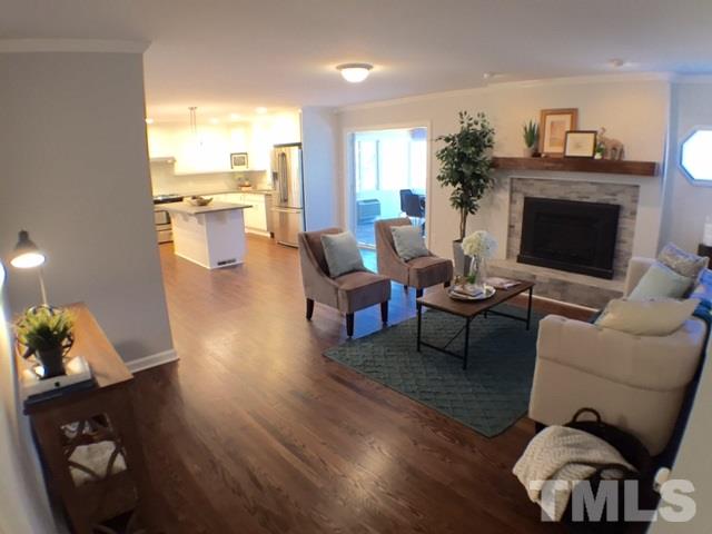 5016 Dantree Place Raleigh, NC 27609 - Photo 2 of 16 a living room with furniture wooden floor and a fireplace