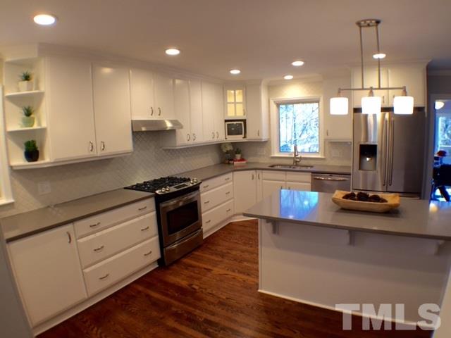 5016 Dantree Place Raleigh, NC 27609 - Photo 5 of 16 a kitchen with stainless steel appliances granite countertop a sink a stove and a wooden floors