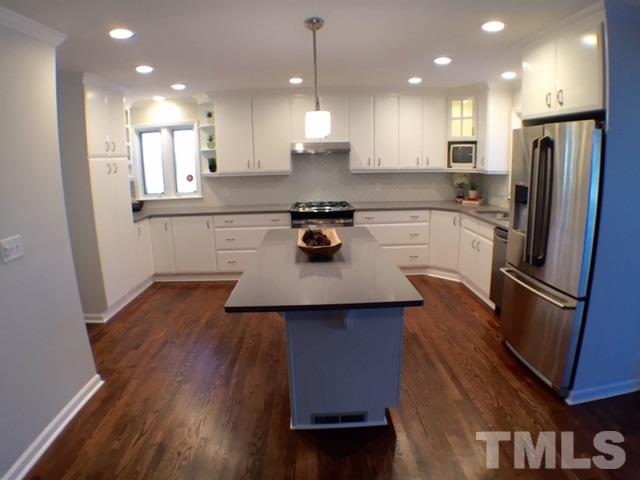 5016 Dantree Place Raleigh, NC 27609 - Photo 6 of 16 a kitchen with a refrigerator a sink dishwasher a stove and a oven with wooden floor