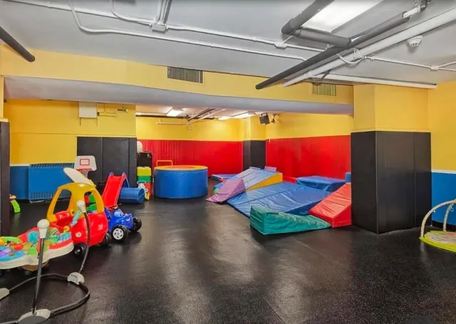 a room with gym equipment and wooden floor