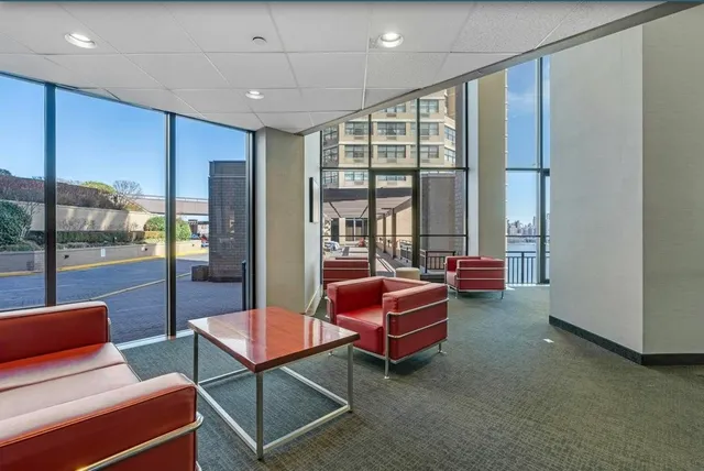 a living room with furniture a ceiling fan and a floor to ceiling window
