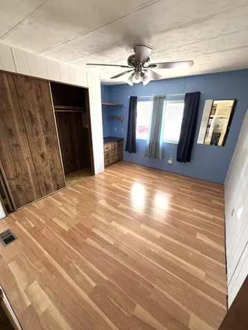 a view of an empty room with window and wooden floor