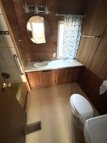 a bathroom with a sink mirror and toilet