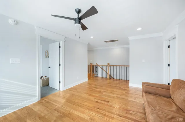 an empty room with windows and ceiling fan