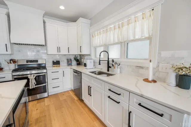 a kitchen with cabinets appliances and a window
