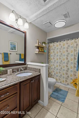 an empty room with a chandelier fan and windows