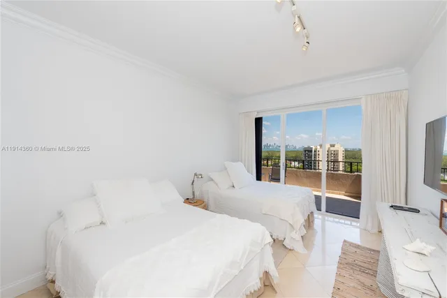 a large white bed in a room next to a window