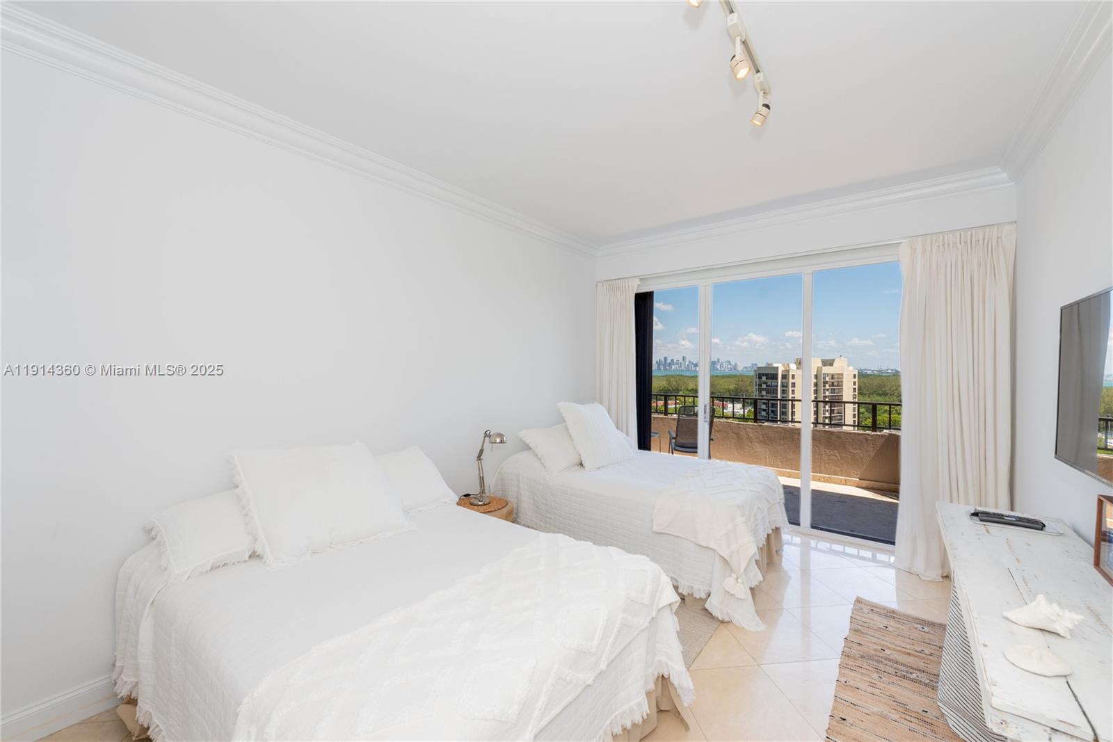 151 Crandon Boulevard, Unit 1036 Key Biscayne, FL 33149 - Photo 16 of 28 a large white bed in a room next to a window