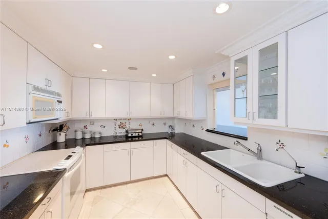 a kitchen with a sink stove top oven and cabinets