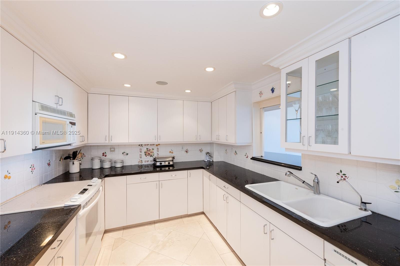 151 Crandon Boulevard, Unit 1036 Key Biscayne, FL 33149 - Photo 8 of 28 a kitchen with a sink stove top oven and cabinets