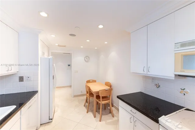 a kitchen with a sink and chairs
