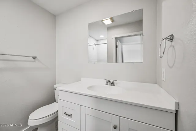 a bathroom with a sink a toilet and a mirror