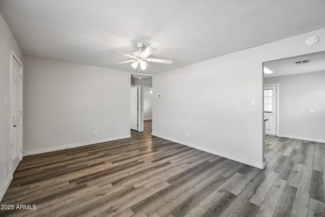 a view of an empty room with a chandelier fan