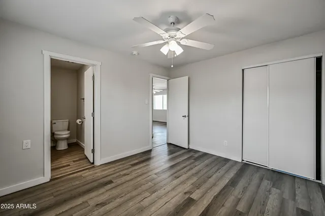 an empty room with wooden floor and closet