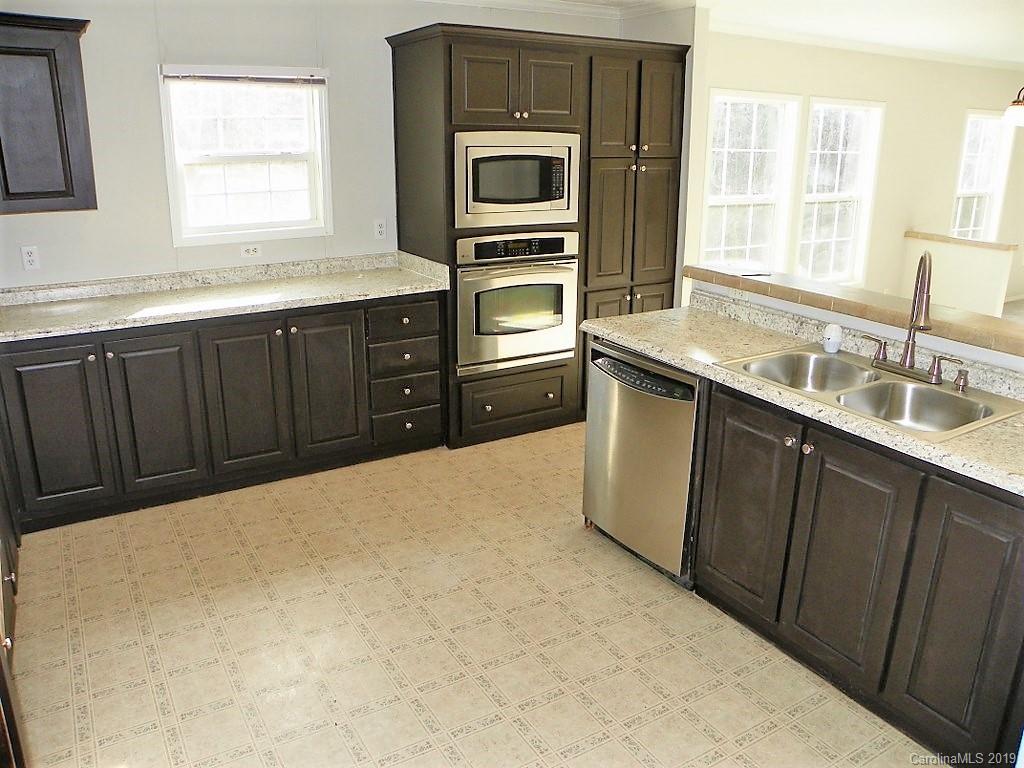 2001 Silver Creek Road Mill Spring, NC 28756 - Photo 15 of 31 a kitchen with a sink stove and microwave