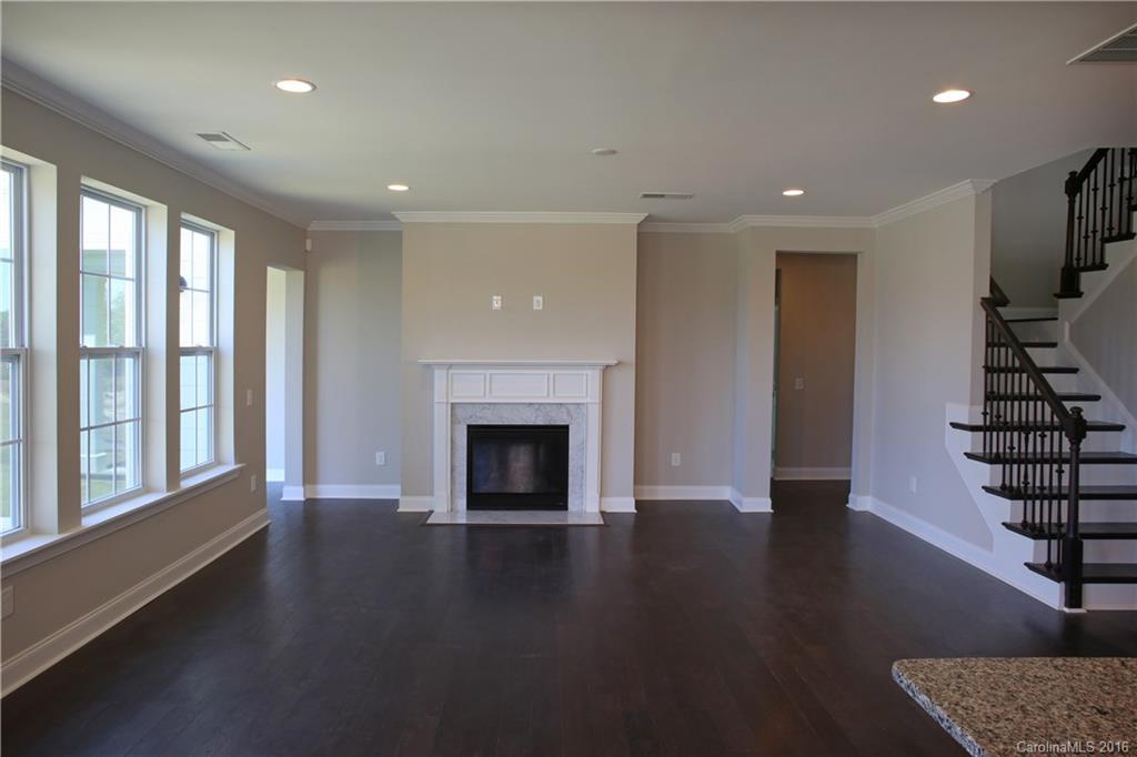 288 Helton Lane, Unit 9 Fort Mill, SC 29708 - Photo 11 of 24 an empty room with wooden floor fireplace and windows