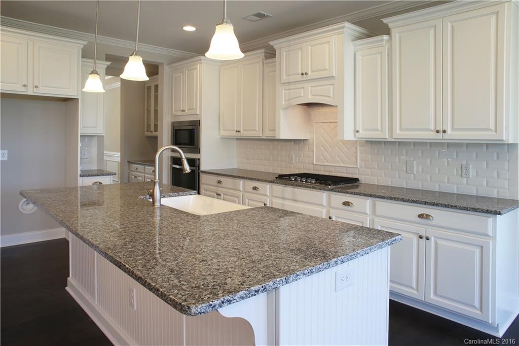 288 Helton Lane, Unit 9 Fort Mill, SC 29708 - Photo 7 of 24 a kitchen with granite countertop a sink a center island stainless steel appliances and cabinets