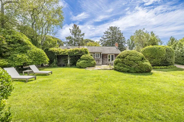 a house view with swimming pool and trees in the background