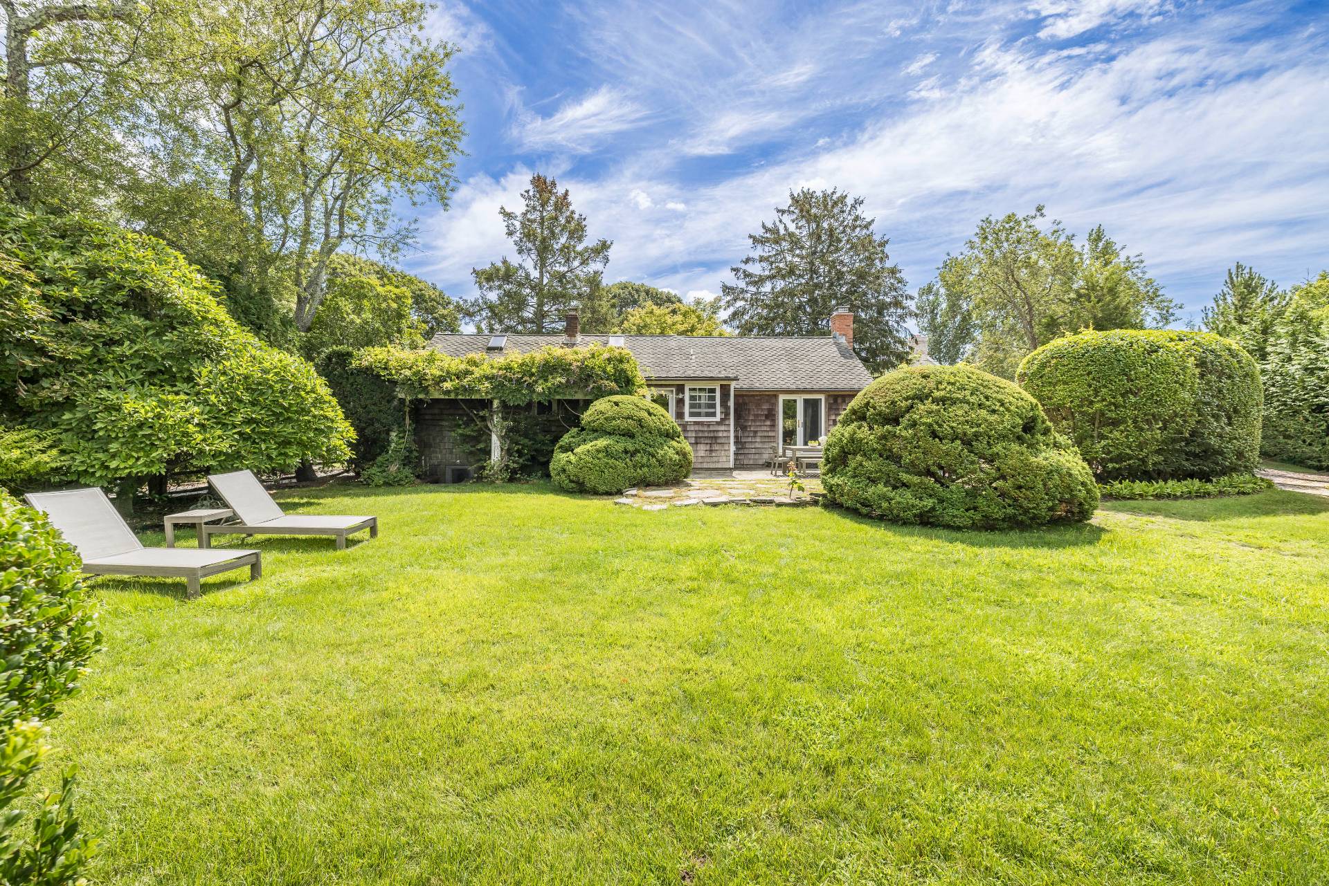 a house view with swimming pool and trees in the background